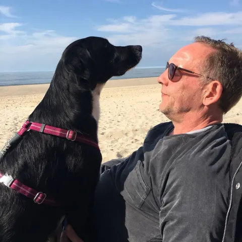 Amy und ihr Mensch am Strand, beide schauen aufs Meer